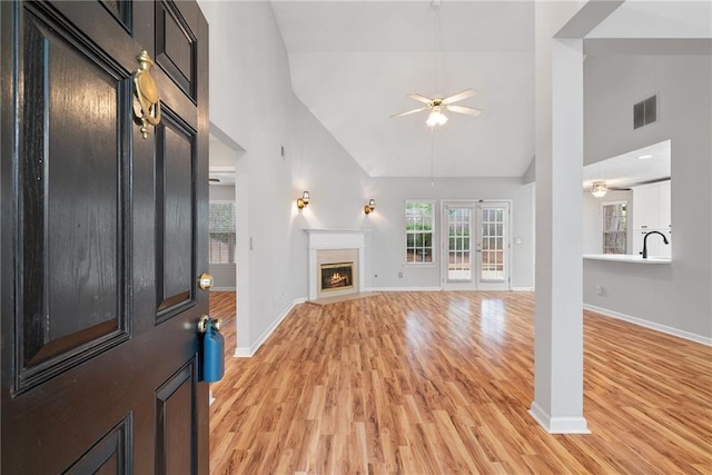 3549 Daventry Ln NW, Kennesaw, GA 30144 - unfurnished living room featuring ceiling fan, high vaulted ceiling, light wood finished floors, and a glass covered fireplace