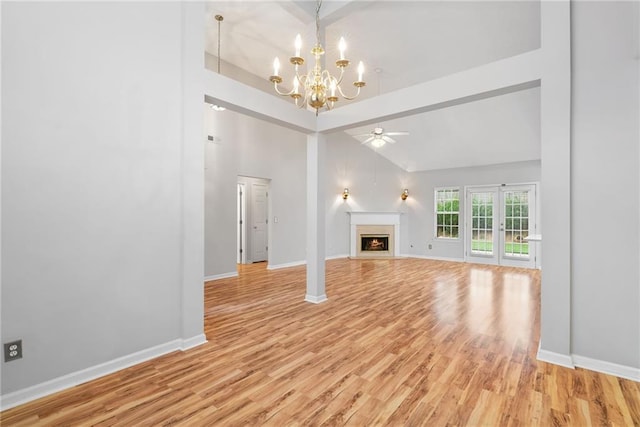 3549 Daventry Ln NW, Kennesaw, GA 30144 - unfurnished living room featuring light wood finished floors, a chandelier, a lit fireplace, a ceiling fan, and high vaulted ceiling