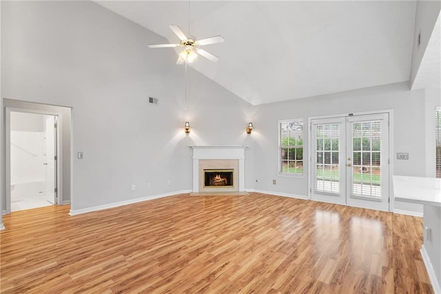 3549 Daventry Ln NW, Kennesaw, GA 30144 - unfurnished living room featuring high vaulted ceiling, light wood-type flooring, a ceiling fan, french doors, and a fireplace with flush hearth