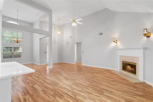 3549 Daventry Ln NW, Kennesaw, GA 30144 - unfurnished living room with high vaulted ceiling, light wood-style floors, ceiling fan, a fireplace with flush hearth, and a chandelier