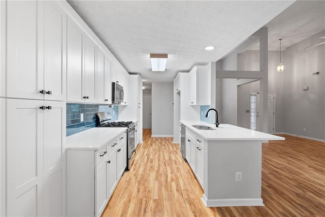 3549 Daventry Ln NW, Kennesaw, GA 30144 - kitchen featuring stainless steel appliances, light wood finished floors, light countertops, decorative backsplash, and white cabinets