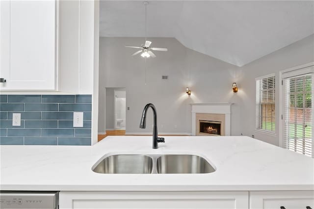 3549 Daventry Ln NW, Kennesaw, GA 30144 - kitchen with ceiling fan, open floor plan, white cabinetry, a warm lit fireplace, and decorative backsplash
