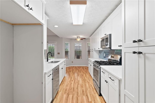 3549 Daventry Ln NW, Kennesaw, GA 30144 - kitchen featuring stainless steel appliances, light countertops, tasteful backsplash, white cabinetry, and a textured ceiling