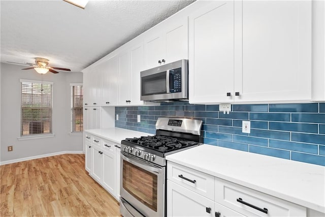 3549 Daventry Ln NW, Kennesaw, GA 30144 - kitchen featuring stainless steel appliances, decorative backsplash, a ceiling fan, light wood-style floors, and light countertops