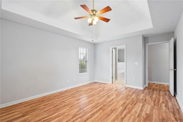 3549 Daventry Ln NW, Kennesaw, GA 30144 - unfurnished bedroom featuring light wood-style floors, a raised ceiling, ensuite bathroom, and a ceiling fan