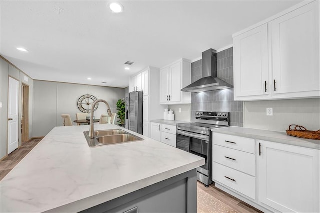 551 Fern Valley Trl NE, Clarkesville, GA 30523 - kitchen with wall chimney range hood, appliances with stainless steel finishes, light wood-style flooring, white cabinetry, and recessed lighting