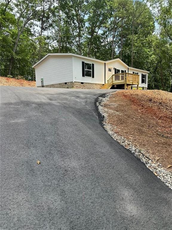 551 Fern Valley Trl NE, Clarkesville, GA 30523 - manufactured / mobile home featuring driveway, crawl space, view of scattered trees, and a deck