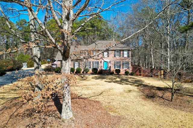 colonial-style house featuring a front lawn