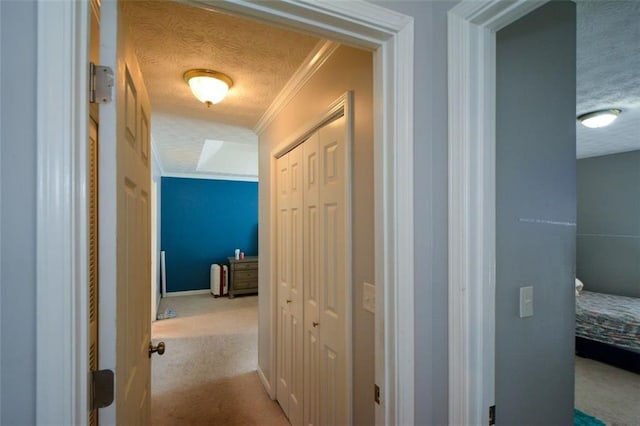 hallway with crown molding, light carpet, and a textured ceiling