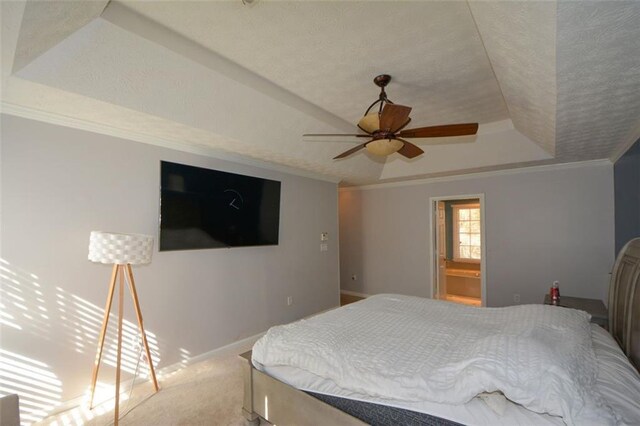 bedroom with crown molding, ceiling fan, a raised ceiling, and carpet