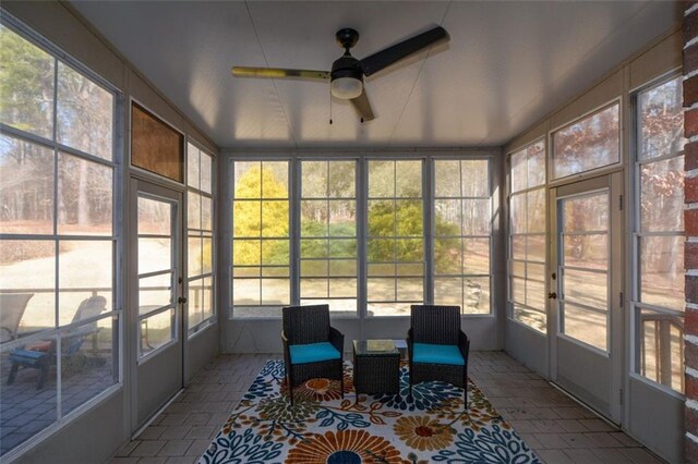 unfurnished sunroom featuring ceiling fan