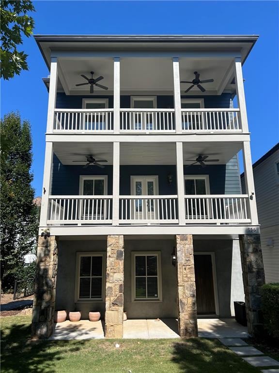 back of property with a balcony and ceiling fan