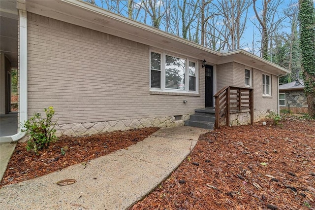 view of front of house with crawl space and brick siding