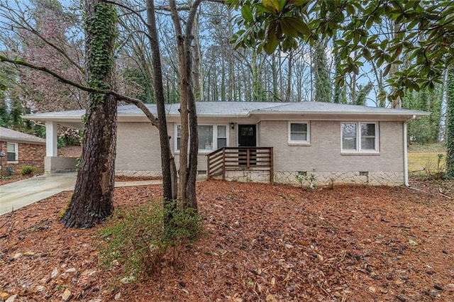 single story home featuring crawl space, an attached carport, concrete driveway, and brick siding