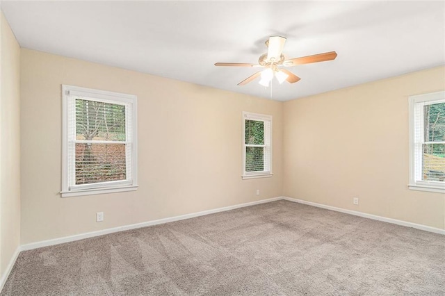 spare room with a ceiling fan, baseboards, a wealth of natural light, and carpet floors