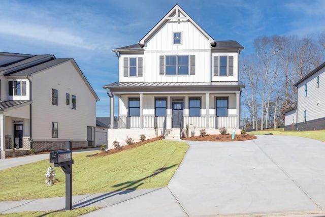 modern farmhouse with board and batten siding, a front lawn, a porch, metal roof, and a standing seam roof