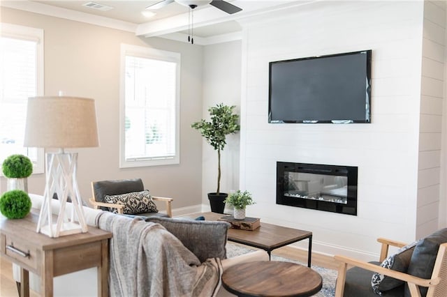 living room featuring wood finished floors, visible vents, baseboards, a fireplace, and ceiling fan