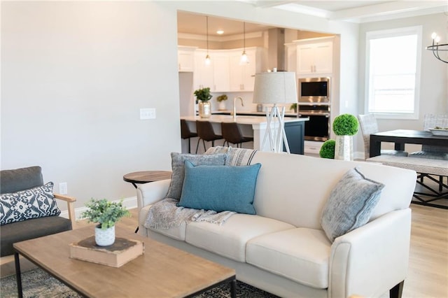 living room with recessed lighting, a chandelier, baseboards, and light wood-style flooring