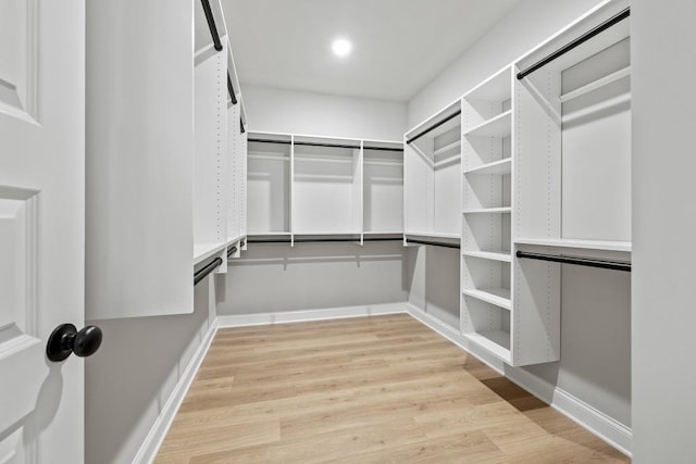 walk in closet with light wood-style floors