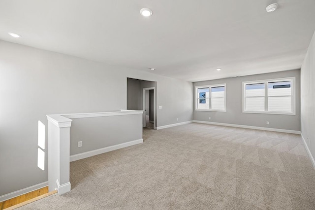 spare room with recessed lighting and baseboards