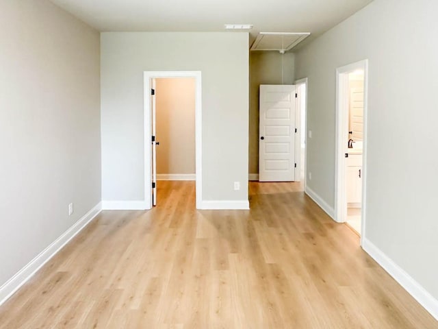 5816 Gainesville St, Flowery Branch, GA 30542 - unfurnished bedroom with attic access, a spacious closet, light wood-type flooring, and baseboards