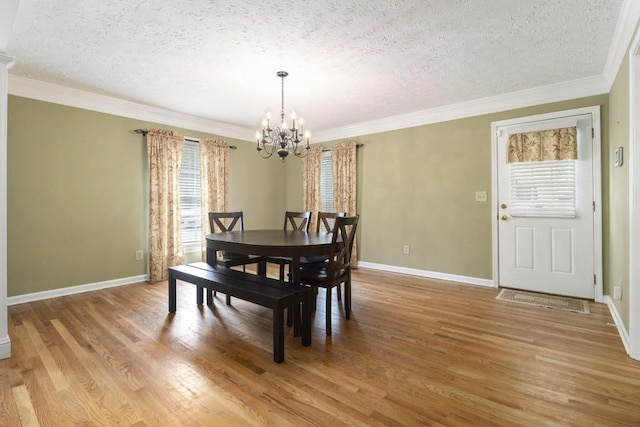 1134 Roscoe Rd, Newnan, GA 30263 - dining room with a textured ceiling, a chandelier, light wood-type flooring, and ornamental molding