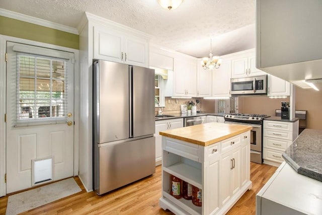 1134 Roscoe Rd, Newnan, GA 30263 - kitchen featuring stainless steel appliances, butcher block counters, a chandelier, white cabinetry, and open shelves