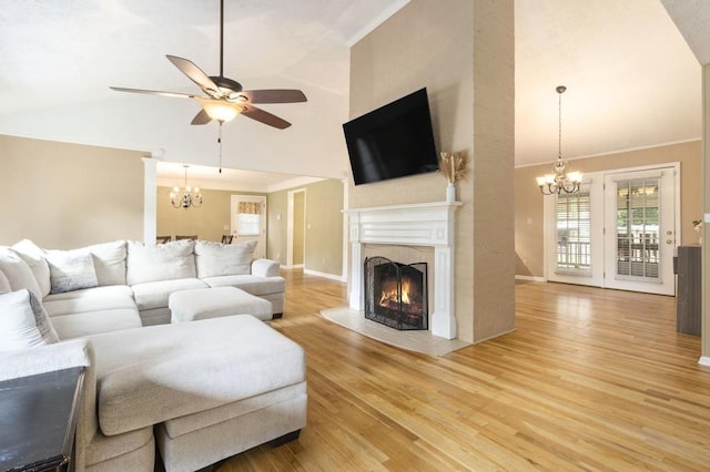 1134 Roscoe Rd, Newnan, GA 30263 - living area featuring a chandelier, high vaulted ceiling, a ceiling fan, light wood-style flooring, and a lit fireplace