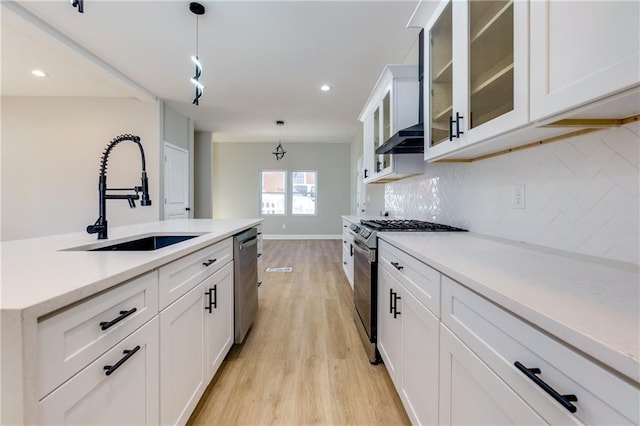 kitchen with white cabinets, hanging light fixtures, and stainless steel appliances