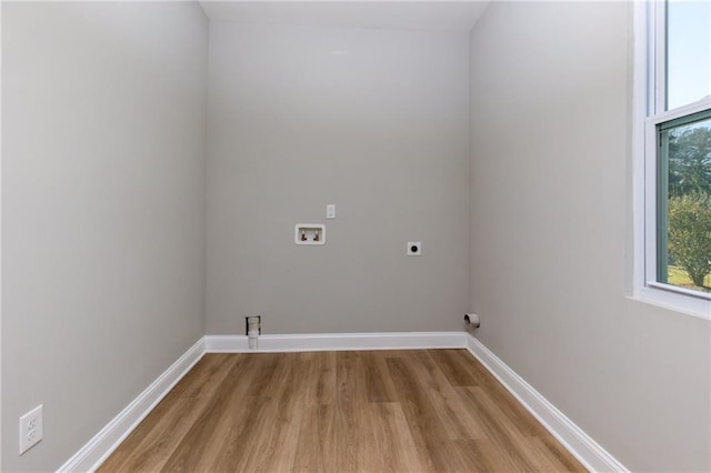 clothes washing area with hookup for an electric dryer, hookup for a washing machine, and light wood-type flooring