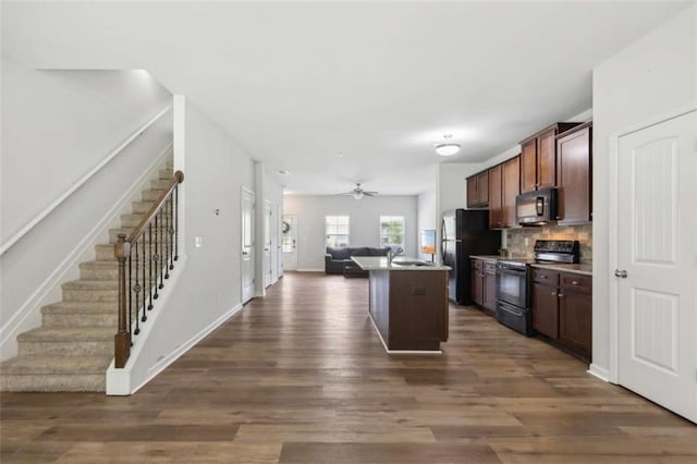 kitchen with a kitchen island, backsplash, dark hardwood / wood-style flooring, ceiling fan, and black appliances