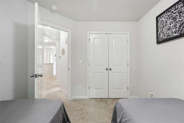 bedroom with light carpet and a closet