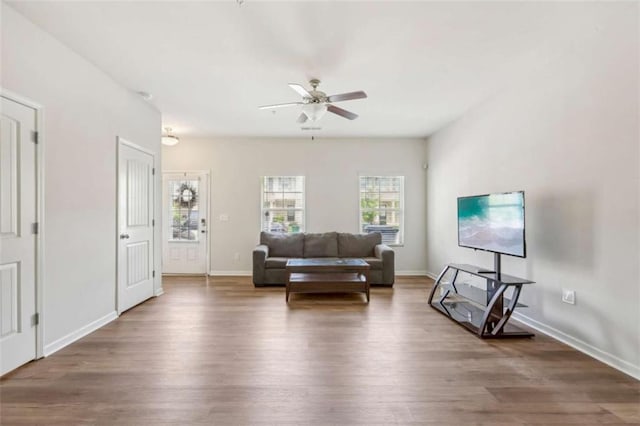 living room with dark hardwood / wood-style flooring and ceiling fan