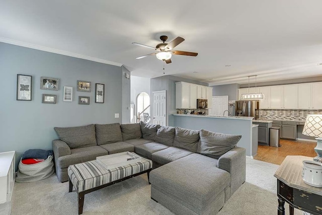 living room with a healthy amount of sunlight, crown molding, and ceiling fan
