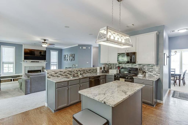 kitchen featuring a sink, black microwave, dishwasher, gas range oven, and gray cabinetry