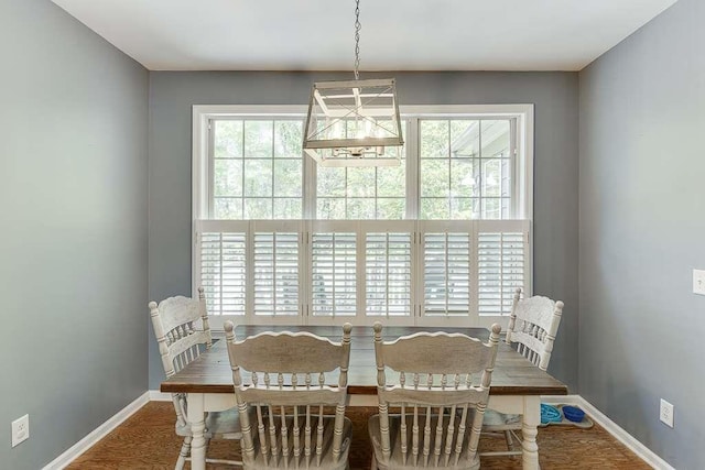 dining space with plenty of natural light, wood finished floors, and baseboards