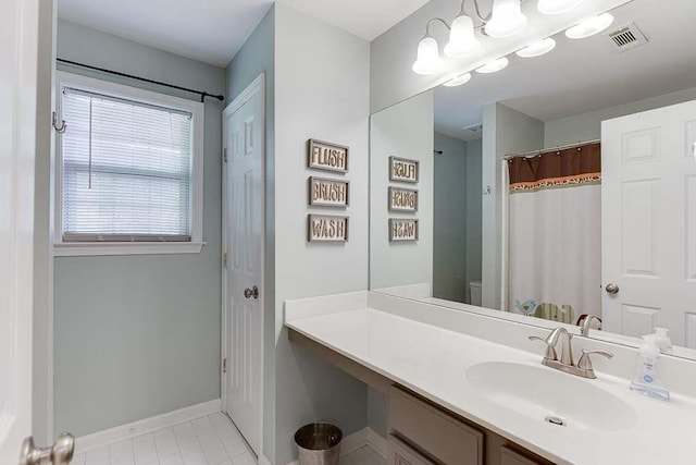 bathroom featuring baseboards, vanity, tile patterned floors, and visible vents
