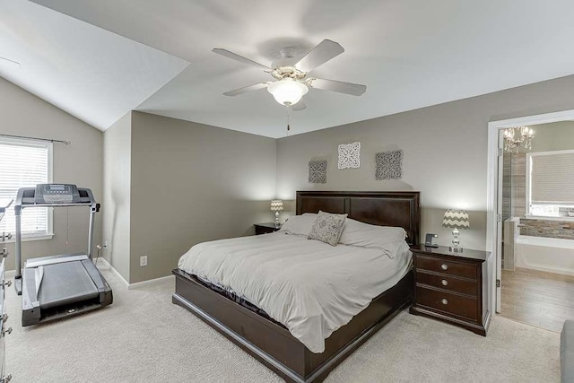 bedroom with a ceiling fan, baseboards, light carpet, and ensuite bathroom