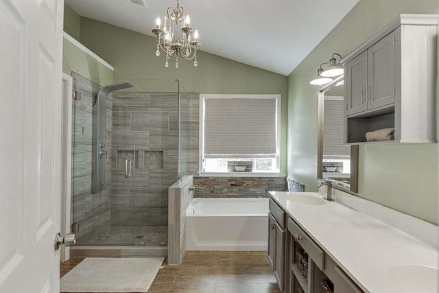 bathroom with a garden tub, vaulted ceiling, a sink, a stall shower, and double vanity