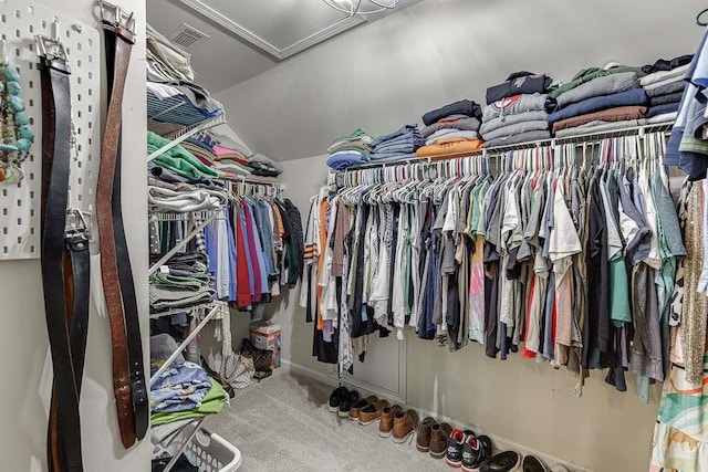 walk in closet with lofted ceiling, visible vents, and carpet