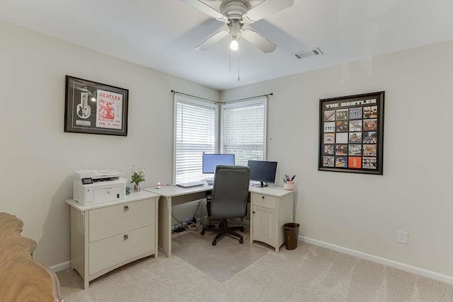 office area with visible vents, a ceiling fan, baseboards, and light carpet