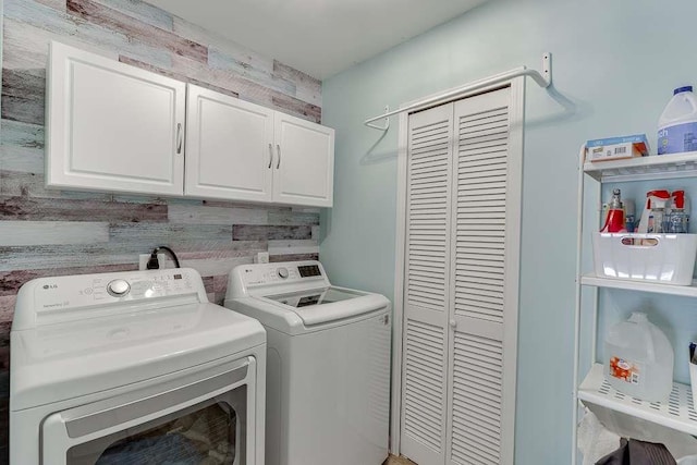 clothes washing area with cabinet space and washing machine and clothes dryer
