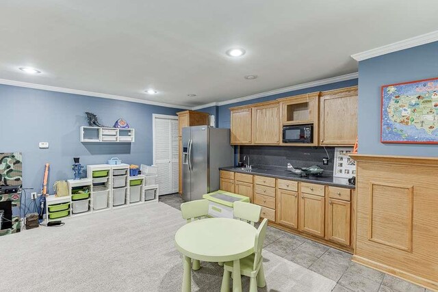 kitchen with dark countertops, tasteful backsplash, black microwave, stainless steel refrigerator with ice dispenser, and ornamental molding