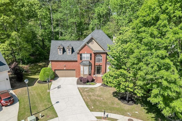 view of front facade with roof with shingles, concrete driveway, brick siding, a front yard, and a garage