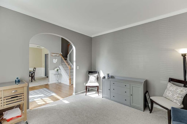 living area featuring carpet flooring, arched walkways, stairway, and crown molding