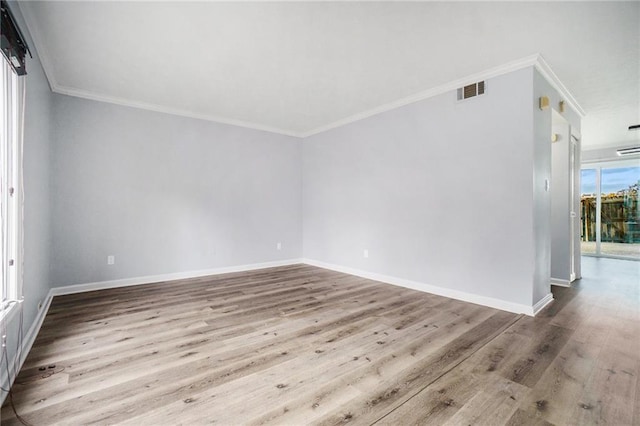 spare room featuring light hardwood / wood-style flooring and ornamental molding