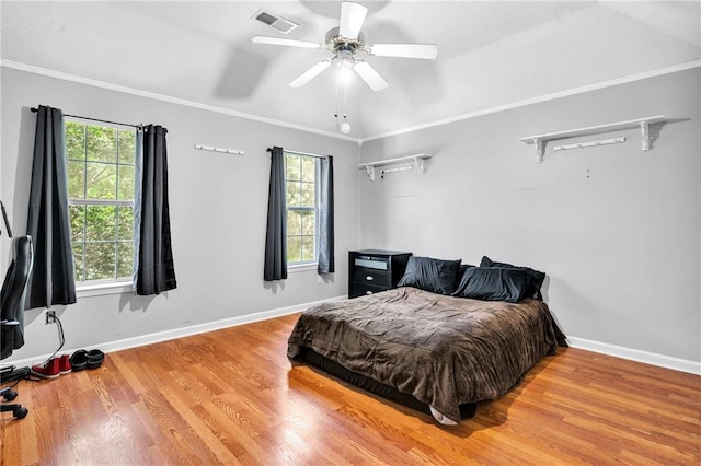 bedroom with multiple windows, ceiling fan, ornamental molding, and hardwood / wood-style flooring