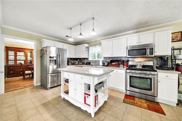 kitchen featuring rail lighting, tasteful backsplash, pendant lighting, white cabinets, and appliances with stainless steel finishes