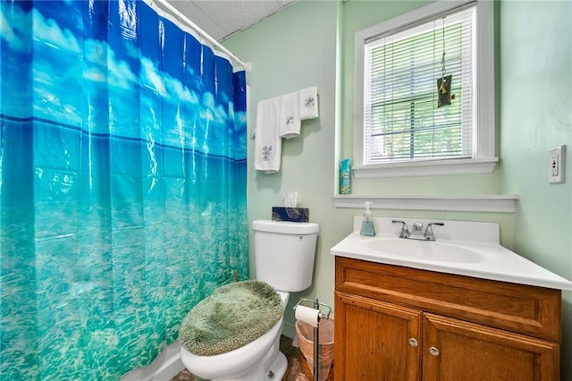 bathroom featuring a shower with shower curtain, vanity, and toilet