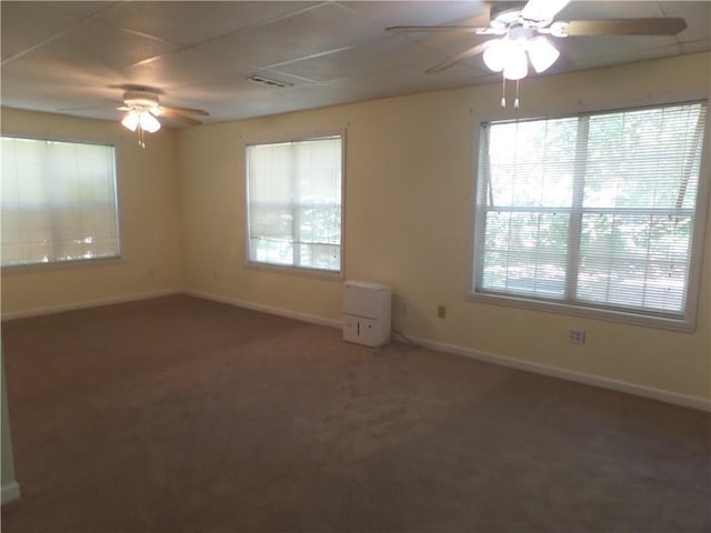 unfurnished room featuring dark colored carpet and ceiling fan